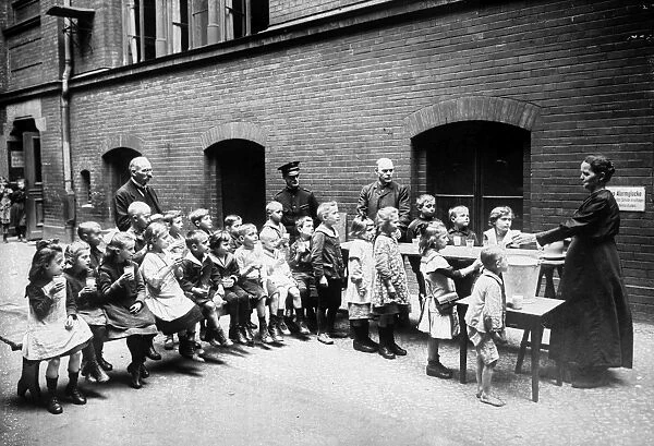 BERLIN: SALVATION ARMY. Salvation Army volunteer feeding Berlin children. Photograph, early 20th century