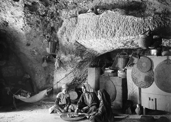 BETHLEHEM: FAMILY. A family in a part-cave house in Bethlehem, with a swaddled baby in a hammock