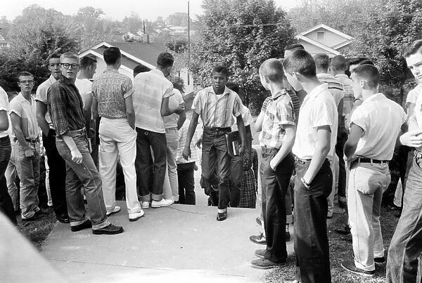 A black student walking through a crowd of white boys in Clinton, Tennessee, during a period of violence related to school integration, 4 December 1956. Photographed by Thomas J. O Halloran
