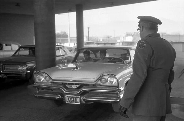 BORDER CROSSING, 1964. United States immigration officer watches cars enter El Paso