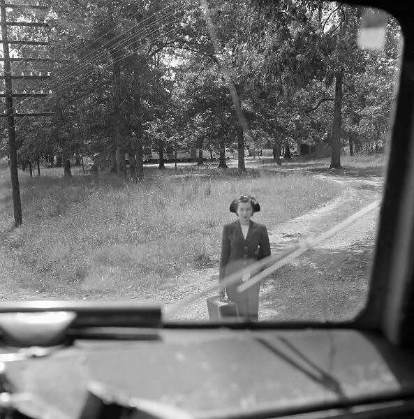 BUS TRAVEL, 1943. Girl waiting for the bus, as seen through bus window, United States