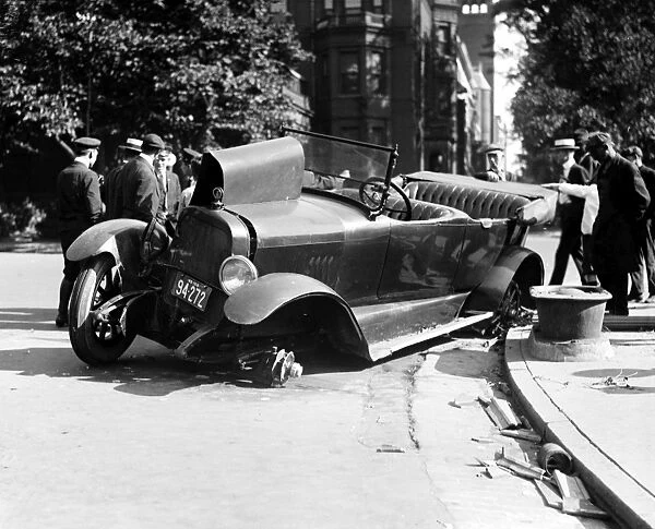CAR ACCIDENT, c1919. Men examining a wrecked car on the side of an American street. Photograph, c1919