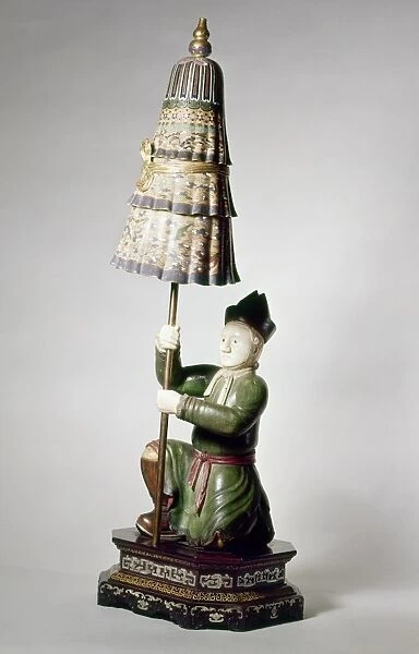 Carved wood and ivory statuette from the reign of Ch ien Lung, depicting a kneeling European holding an enamel lotus, Buddhist symobl of purity. Ching Dynasty, 1736-1796