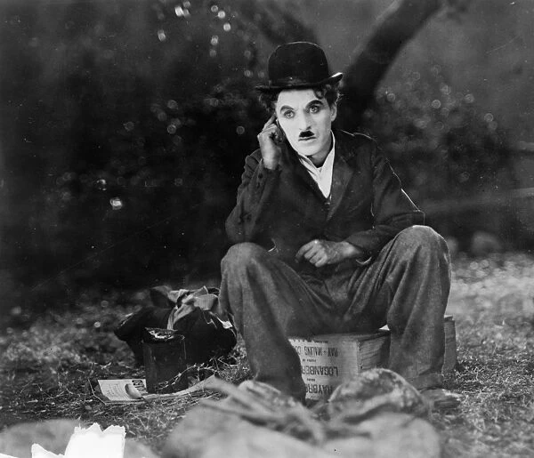 CHAPLIN: THE CIRCUS, 1928. Charlie Chaplin seated on a crate in the film The Circus
