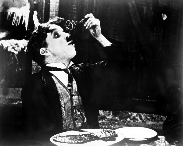 CHAPLIN: GOLD RUSH. 1925. Charlie Chaplin eating his shoe in a scene from his film The Gold Rush, 1925