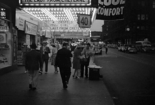 CHICAGO, 1941. Pedestrians on the street outside of a theatre in Chicago, Illinois