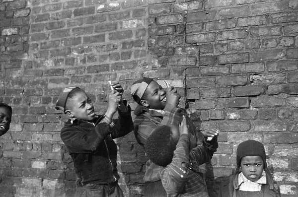 CHICAGO: BOYS, 1941. Boys playing that they are shooting machine guns at an airplane