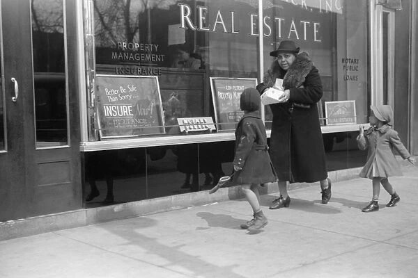 CHICAGO: FAMILY, 1941. An African American family in front of a real estate office in Chicago