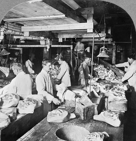 CHICAGO: MEATPACKING, c1915. Workers trimming and skimming hams before pickling