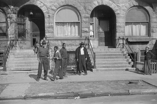 CHICAGO: STREET SCENE, 1941. Group of people outside of an apartment building