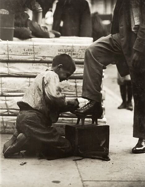 CHILD LABOR: BOOTBLACK, 1910. Young bootblack at work on the Bowery, New York City