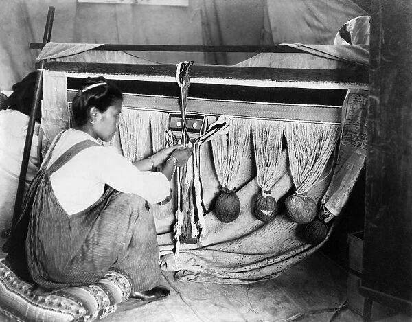 CHILKAT WEAVING, c1910. A Chilkat woman weaving a blanket in Alaska. Photograph by Winter & Pond
