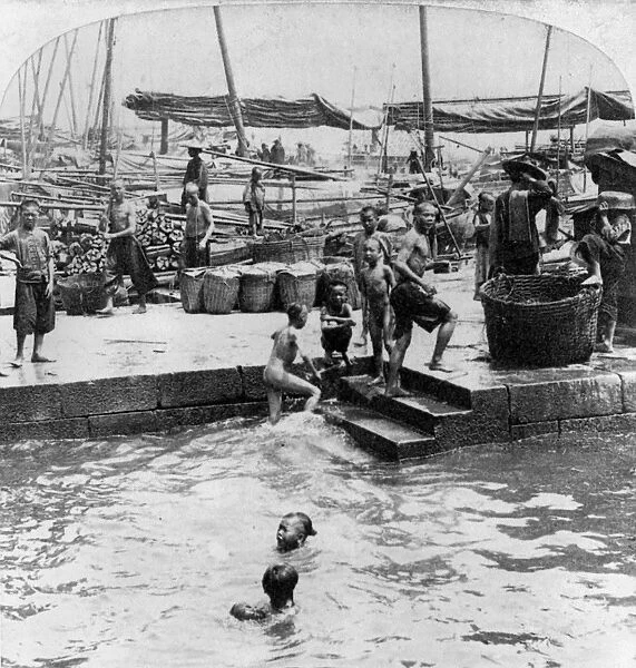 CHINA: HONG KONG, c1897. Children swimming and playing along the wharf in Hong Kong, China