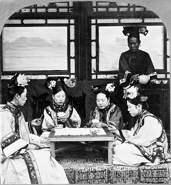 CHINA: PEKING, c1902. Four Manchurian women playing cards and having tea, Peking, China