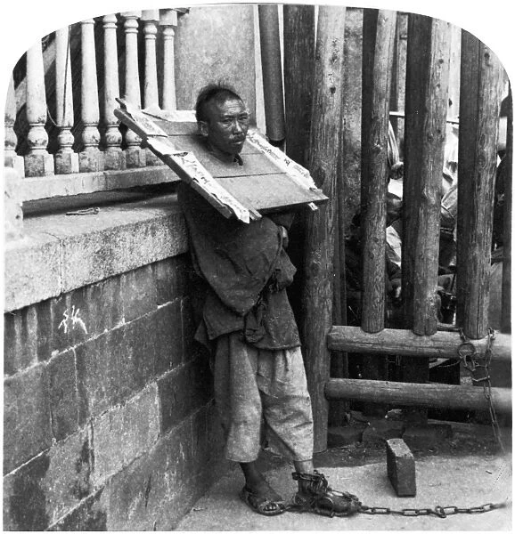 CHINA: PUNISHMENT, c1900. A criminal in China chained by the ankle to a fence