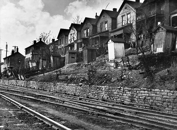 CINCINNATI: HOUSES, 1935. A row of low-income houses with outhouses facing railroad tracks, Cincinnati, Ohio. Photograph by Carl Mydans in December 1935