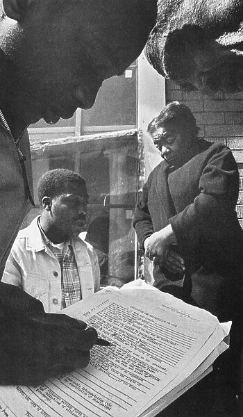 Two civil rights activists help an African American couple from Mississippi register to vote during the Freedom Summer of 1964