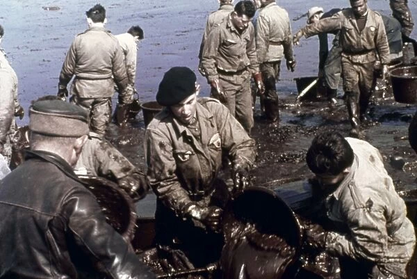 Cleanup efforts on a French beach after an oil spill at sea. Photographed c1970