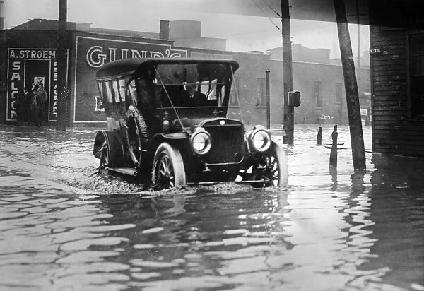 CLEVELAND: FLOOD, c1913. A car driving down a flooded street in Cleveland, Ohio, c1913