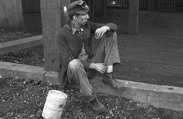 COAL MINER, 1935. A coal miner taking a break from working at the Consolidated Coal Company