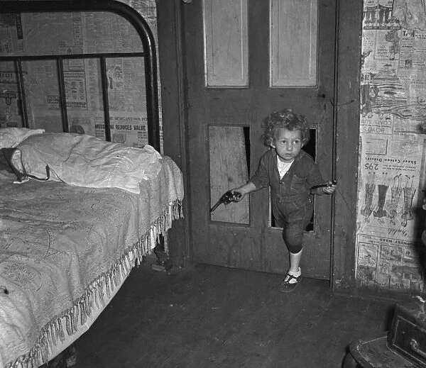 COAL MINER'S CHILD, 1938. Coal miners child using a hole in the door to enter