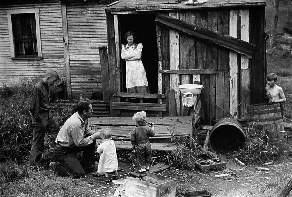 COAL MINERs FAMILY, 1938. A coal miner and his family at their home in Bertha Hill