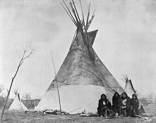 COMANCHES, c1880. A group of four Comanche people seated in front of a tipi