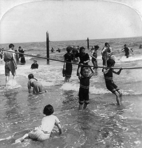 CONEY ISLAND: BEACH, c1897. Children holding onto ropes and playing in the surf at Coney Island
