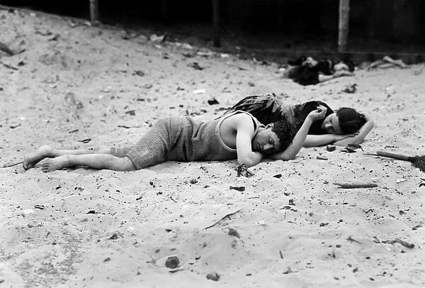 CONEY ISLAND: SLEEPING. A couple sleeping on the sand under the boardwalk. Coney Island, Brooklyn, New York. Photograph, early 20th century