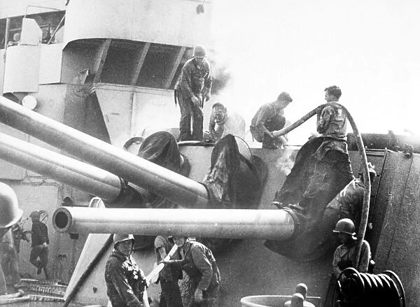 Crew members fighting a fire in the gun turret of the U. S. S. Savannah, a light cruiser, off the coast of Salerno, Italy. Photographed November 1943