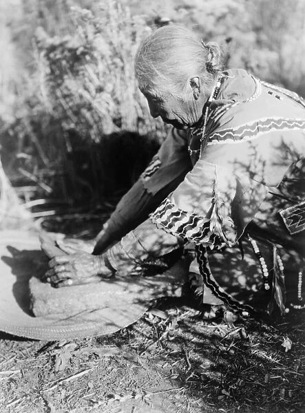 CURTIS: KLAMATH WOMAN. A Klamath Native American woman in Oregon grinding wokas