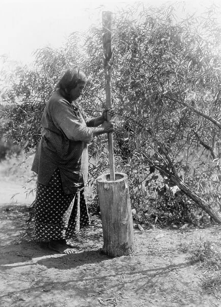 CURTIS: WICHITA WOMAN. A Wichita Native American woman using a large mortar and pestle