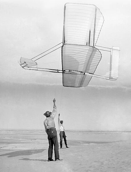 Dan Tate (left) and Wilbur Wright, flying a glider as a kite at Kitty Hawk, North Carolina. Photographed by Orville Wright, 19 September 1902