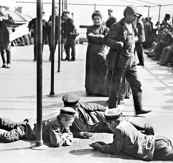 Detained immigrants awaiting approval to enter the United States, amusing themselves on the rooftop of the main building at Ellis Island, New York City. Photograph, c1907