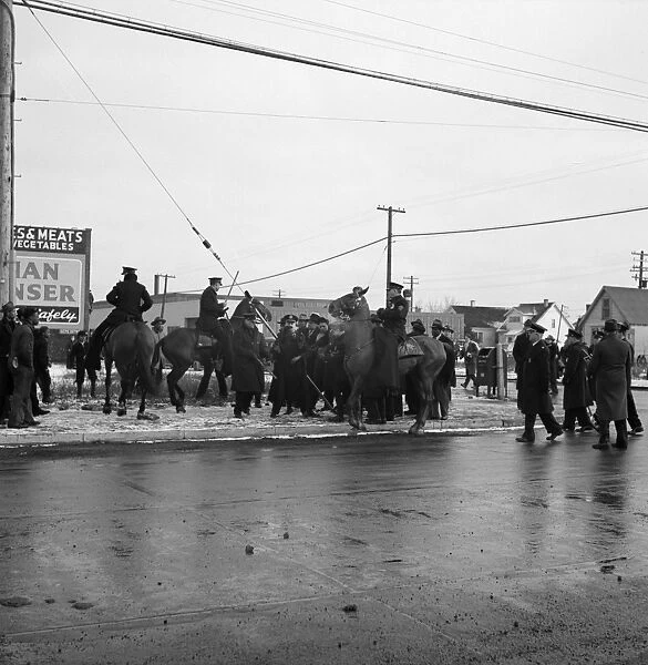DETROIT, 1942. Mounted police surrounding a group of black men during a riot caused