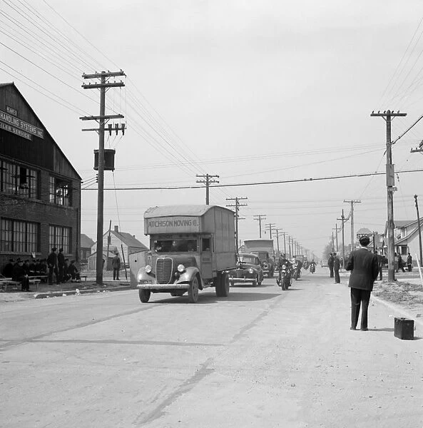 DETROIT, 1942. Moving vans, with a police escort, moving black families belongings
