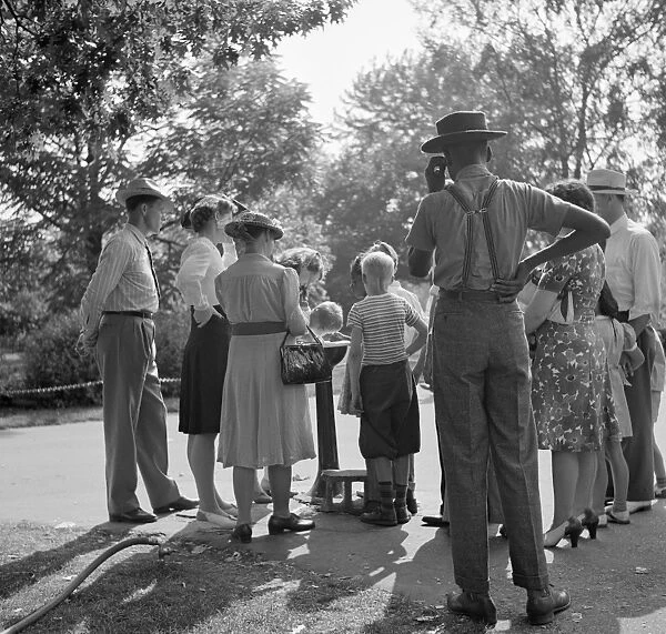 DETROIT, 1942. People waiting to drink from a water fountain at the zoo in Detroit, Michigan