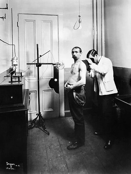 A doctor examining a patient in St. Marks (German) Hospital on Second Avenue and 10th Street in New York City. Photograph, 1904