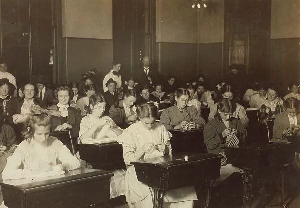 DRESSMAKING CLASS, 1909. Working girls learning dressmaking in a free evening class