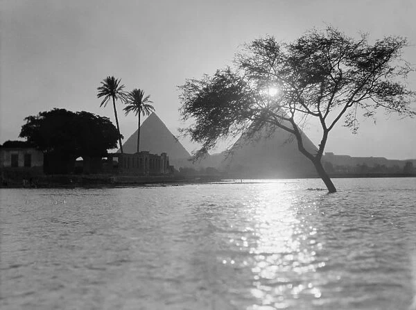 EGYPT: NILE, c1934. A view of the pyramids along the Nile River at sunset. Photograph