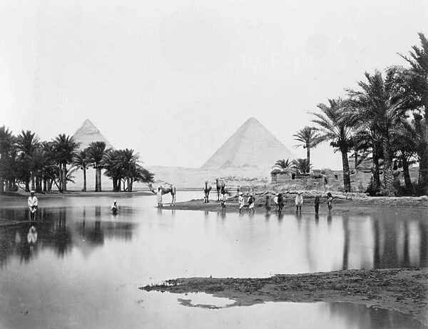 EGYPT: PYRAMIDS. A view of the pyramids with people wading in a lake in the foreground. Photograph, mid or late 19th century