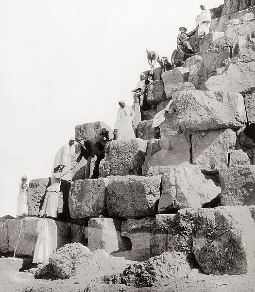 EGYPT: TOURISM, c1890s. European ladies ascending a pyramid at Giza with the help of their escorts and Egyptian guides. Photograph, c1890s