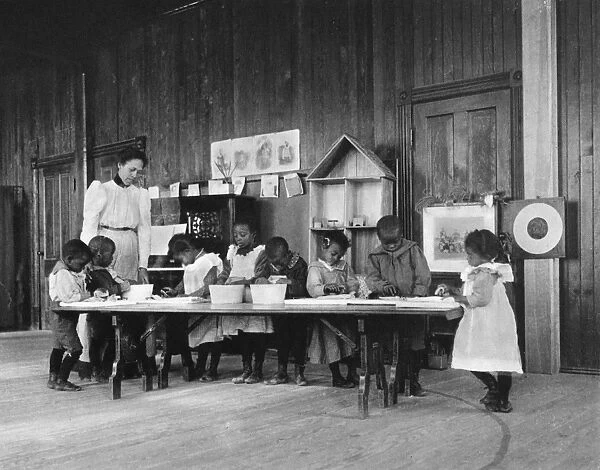 ELEMENTARY SCHOOL, c1900. Kindergarten students washing and ironing at Whittier Elementary School