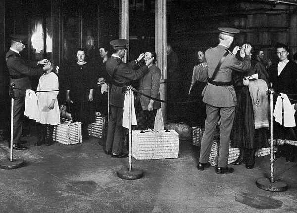 ELLIS ISLAND: EXAMINATION. Immigrants being examined for eye diseases at Ellis Island, early 20th century