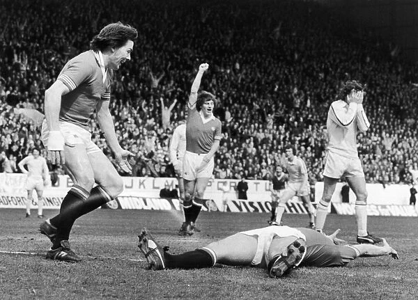 ENGLAND: SOCCER GAME, 1977. Stuart Peterson (left) and Steve Coppell of Manchester United FC congratulate Jimmy Greenhoff (on ground) for scoring the first goal against Leeds United during the FA Cup semi-final game, 1977. Frank Gray (right) of Leeds United holds his head