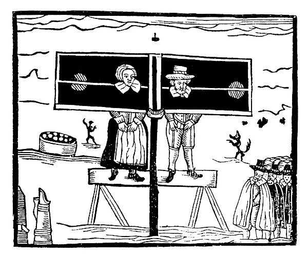 ENGLISH PILLORY. A man and a woman standing in a pillory while villagers stand and jeer