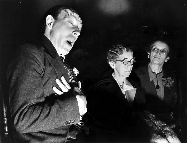 ENGLISH SEANCE. The medium Horace S. Hambling in a trance, insisting the spirit of Moon Trail, a dead Indian, is speaking through him; photographed in 1937