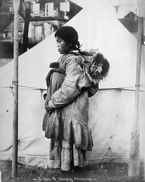 ESKIMO WOMAN AND CHILD. An Eskimo woman carrying a baby on her back, Arctic region