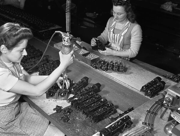 Factory workers Stephanie Cewe (left) and Ann Manemeit at work at a toy factory in New Haven, Connecticut. Stephanie assembles toy trains while Ann attaches the trains to their chassis. The factory was later converted to manufacture parachute flare casings during World War II. Photograph by Howard R. Hollem, 1942