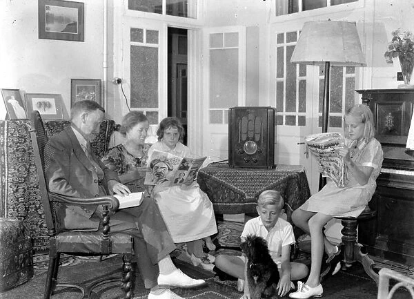 FAMILY, 1930s. A family in Jerusalem seated around a radio, reading. Photographed between 1937